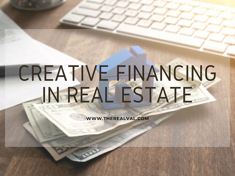 Creative financing in real estate concept with money, house model, and keyboard on a desk.