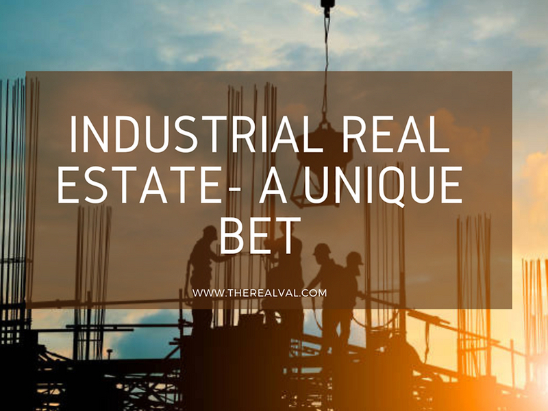 Silhouetted workers on a construction site at sunset promoting industrial real estate opportunities.